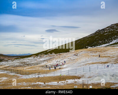 Irriconoscibile persone scivolando sul ghiaccio in un pendio in montagna su La Covatilla, Bejar (Salamanca) Foto Stock