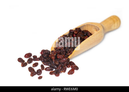 Primo piano della rossi secchi barberries, una buona fonte di vitamina C, presentato su un piccolo cucchiaio di legno Foto Stock