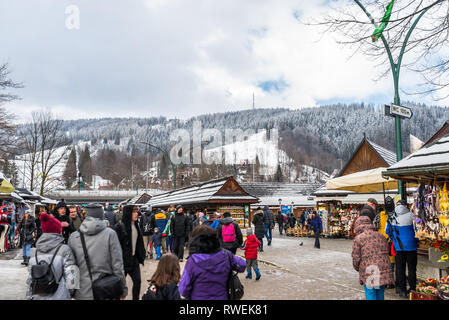 Zakopane, Polonia - 22 febbraio 2019. Una folla di persone a piedi lungo Krupowki street su un giorno d'inverno. Krupowki street è la città principale promenade Foto Stock