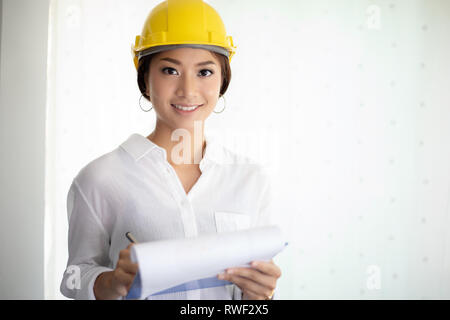 Donne asiatiche engineering ispezione e del lavoro e di azienda blueprint in ufficio Foto Stock