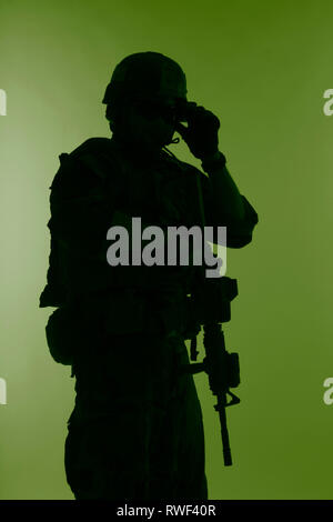 Silhouette di U.S. Marine Corps Marsoc raider con arma, sfondo verde. Foto Stock