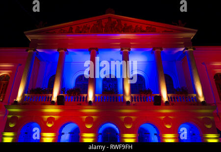 Il Teatro Sucre illuminato con rosso, giallo e blu nel centro storico della città di Quito, Ecuador. Foto Stock