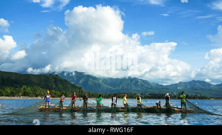 I pescatori tirando grandi reti da zattera di bambù, noto come Lambaklad Pesca - Tibiao, antichi - Filippine Foto Stock