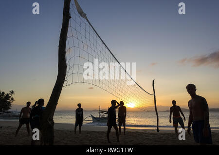Gioco di pallavolo e giocatori su generale Luna spiaggia al tramonto - Siargao, Filippine Foto Stock