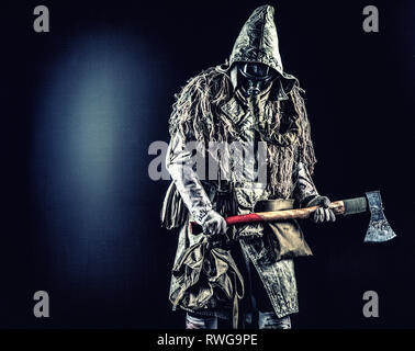 Post-apocalittico superstite indossando maschera a gas e strappati i vestiti, minacciando con ax. Foto Stock
