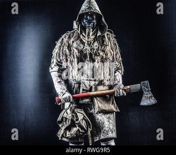 Post-apocalittico superstite indossando maschera a gas e strappati i vestiti, minacciando con ax. Foto Stock