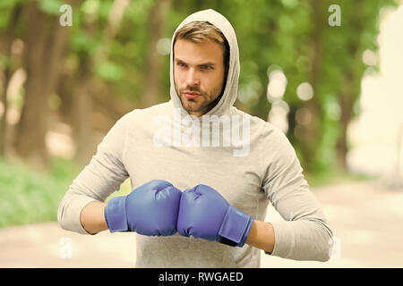 Io sono pronto a combattere. L'uomo atleta sulla faccia di concentrato con guanti sport praticando la boxe punch, natura dello sfondo. Boxer testa cofano pronti a combattere. Boxer sportivo della formazione con i guantoni. Foto Stock