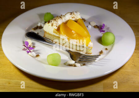 Crostata di pesche e crema. Una forcella si trova sulla piastra. Foto Stock