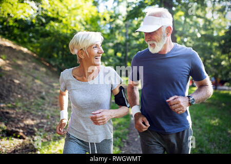 Montare felice coppia senior che esercitano in posizione di parcheggio Foto Stock