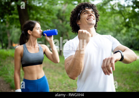 Atletica Giovane amico acqua potabile dopo l'esecuzione Foto Stock