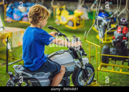 Ai bambini di andare su Merry Go Round, bambini a giocare sulla giostra in estate Foto Stock