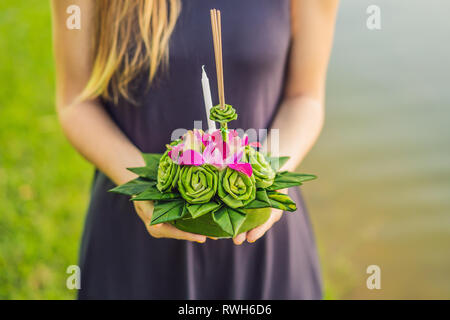 Giovane donna celebra Loy Krathong, corre sull'acqua. Loy Krathong festival, la gente compra i fiori e candela alla luce e galleggiare su acqua per celebrare Foto Stock