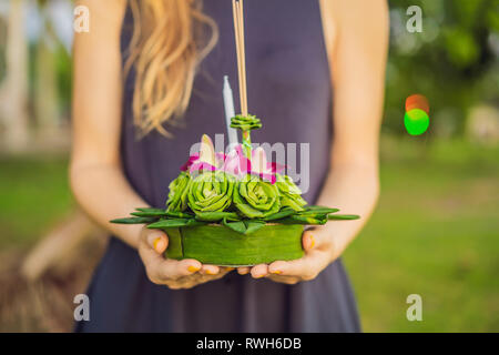 Giovane donna celebra Loy Krathong, corre sull'acqua. Loy Krathong festival, la gente compra i fiori e candela alla luce e galleggiare su acqua per celebrare Foto Stock