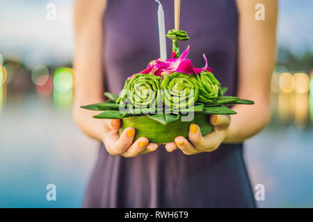 Giovane donna celebra Loy Krathong, corre sull'acqua. Loy Krathong festival, la gente compra i fiori e candela alla luce e galleggiare su acqua per celebrare Foto Stock