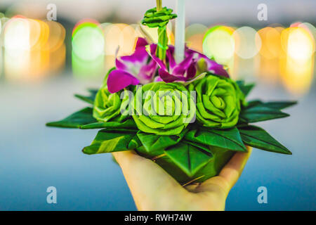 Giovane donna celebra Loy Krathong, corre sull'acqua. Loy Krathong festival, la gente compra i fiori e candela alla luce e galleggiare su acqua per celebrare Foto Stock