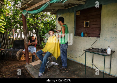 Artemisa, Cuba. 29 Maggio, 2009. Lavoratore agricolo si ottiene un taglio di capelli in un barbiere rurali al di fuori Artemisa, Cuba. Foto Stock