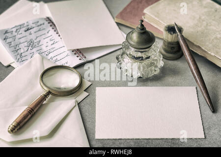 Set di cancelleria vintage, penna in legno, inkwell, Magnifier e buste, lettere da vicino. Scrivere una lettera. Memoria e concetto di nostalgia Foto Stock