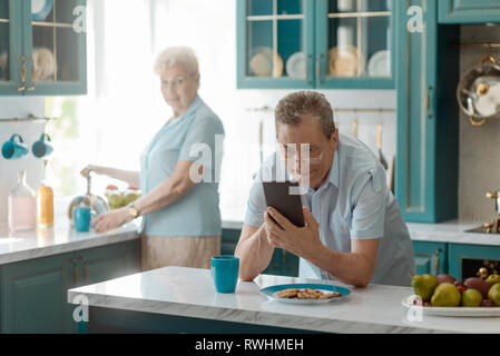 Il nonno navigando attraverso web Foto Stock