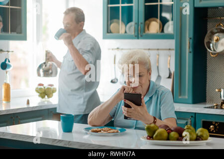 Nonnina utilizzando un telefono cellulare Foto Stock