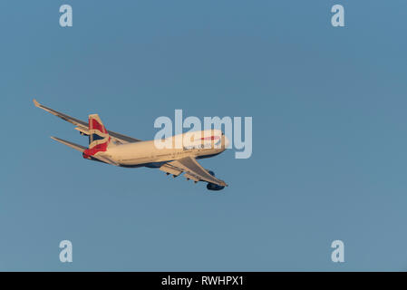 British Airways Boeing 747 Jumbo Jet aereo di linea G-BNLY decolla dall'aeroporto di Londra Heathrow, Regno Unito, nel cielo blu al tramonto Foto Stock