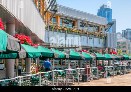 La gente seduta fuori a mangiare al Molo 66 in Seattle. Foto Stock