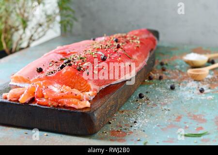 Gravlax, barbabietole scandinavo indurito salmone speziato sul bordo, vista dall'alto, salate pesce rosso Foto Stock