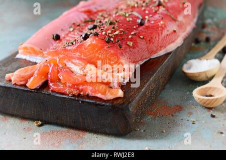 Gravlax, barbabietole scandinavo indurito salmone speziato sul bordo, vista dall'alto, salate pesce rosso Foto Stock