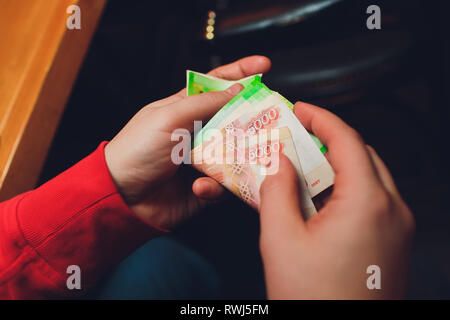 Gli uomini con le mani in mano contare il denaro russo close up Foto Stock