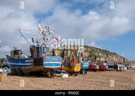 Hastings, East Sussex, Regno Unito. Il 7 marzo 2019. Hastings barche da pesca tirato su in alto sulla Città Vecchia Stade di pescatori di spiaggia al di fuori della portata del mare in forte blustery condizioni ventose. Con più di 25 barche di Hastings ha la più grande spiaggia-lanciato della flotta da pesca in Europa. Foto Stock