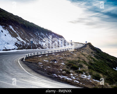 Molto curva chiusa su un pericoloso alta strada di montagna con cielo nuvoloso e neve su La Covatilla, Bejar (Salamanca) Foto Stock