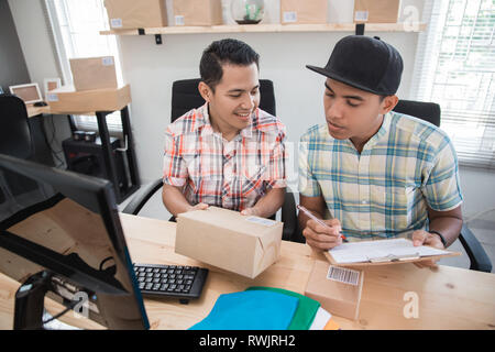 Ecommerce lavoratore. l uomo con il partner e del prodotto Foto Stock