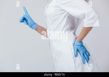Donna dottore le mani in medical lattice guanti blu puntando su qualcosa di Foto Stock