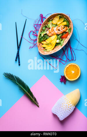 Hawaiian poke ciotola con gamberetti, noodle e mango. Asian Food trendy sashimi. Vista superiore, piatto laici. Foto Stock