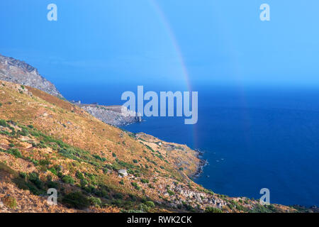 Selvatica costa collinare di Creta isola dopo una pioggia con un arcobaleno Foto Stock