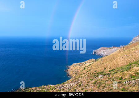 Selvatica costa collinare di Creta isola dopo una pioggia con un arcobaleno Foto Stock