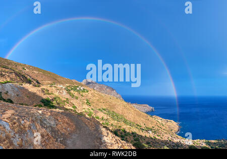 Selvatica costa collinare di Creta isola dopo una pioggia con un arcobaleno immagine panoramica Foto Stock