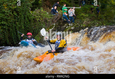 Kayak in gara scendono rapids con gli spettatori a guardare dal litorale al kayak Carna evento; Buncrana, County Donegal, Irlanda Foto Stock