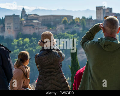 Turisti che si siedono in vista dell'Alhambra; Granada, Andalusia, Spagna Foto Stock