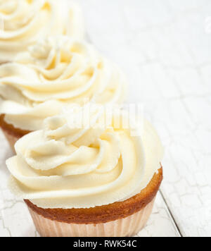 Bianco tortini di vaniglia in una fila. focus sul cupcake anteriore Foto Stock