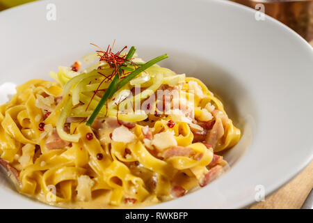 La pasta alla carbonara fatta con uova con pancetta e formaggio parmigiano Foto Stock