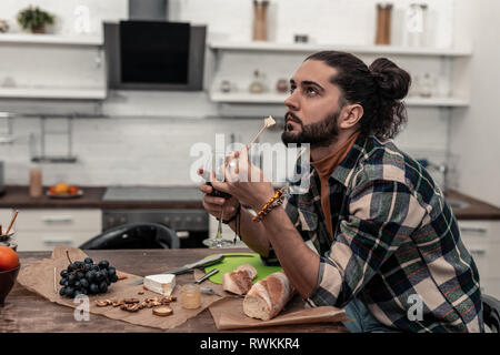 Nizza uomo premuroso cercando il gusto del formaggio Foto Stock