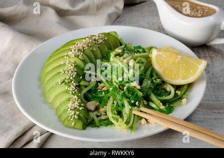 Chukka, insalata di cetrioli con le tagliatelle di avocado e arachidi salsa marrone in sauceboat Foto Stock