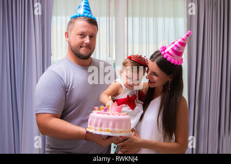 Famiglia celebra la loro figlia del primo compleanno, un anno di età, una torta, un close-up. happy family concept. Foto Stock