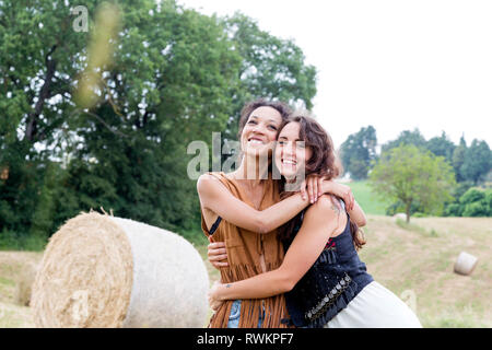 Amici nel campo delle balle di fieno, Città della Pieve, Umbria, Italia Foto Stock