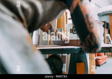 Ax lavorando su legno per ax maniglia in officina Foto Stock