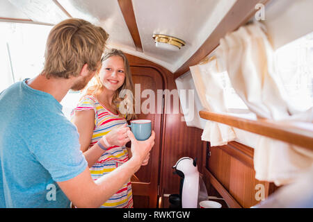Coppia giovane in barca a vela cabin bollitore per caffè Foto Stock