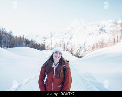 Giovane donna in knit hat in paesaggi innevati, Alpe Ciamporino, Piemonte, Italia Foto Stock