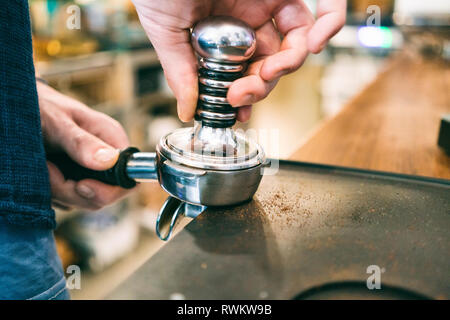 Barista timbratura caffè nel bar caffè Foto Stock