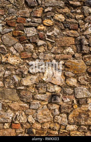 Un muro fatto di grandi rocce e cemento, grande per uno sfondo o sfondo, arance e toni di colore giallo Foto Stock