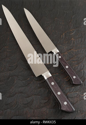 Due mai utilizzato i coltelli da cucina in legno nero board Foto Stock